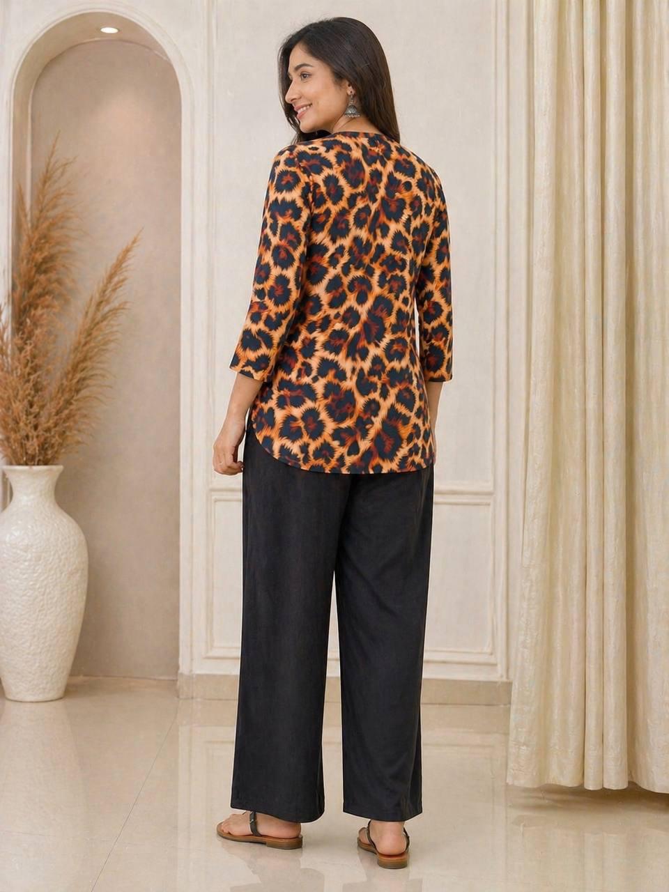 Woman wearing a leopard print top and black pants in an indoor setting.